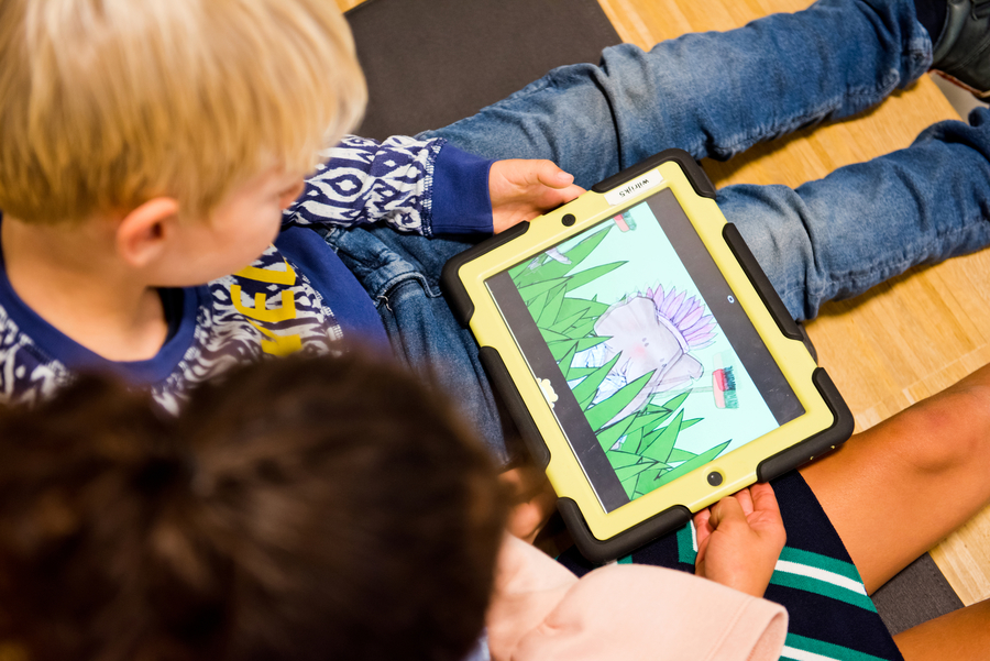Twee kleine kinderen kijken samen naar een animatie-olifant op een tablet. Twee kleine kinderen kijken samen naar een animatie-olifant op een tablet.